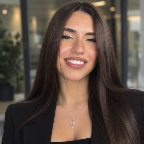 Ria Karakasis, cyber security analyst, smiling in a black blazer